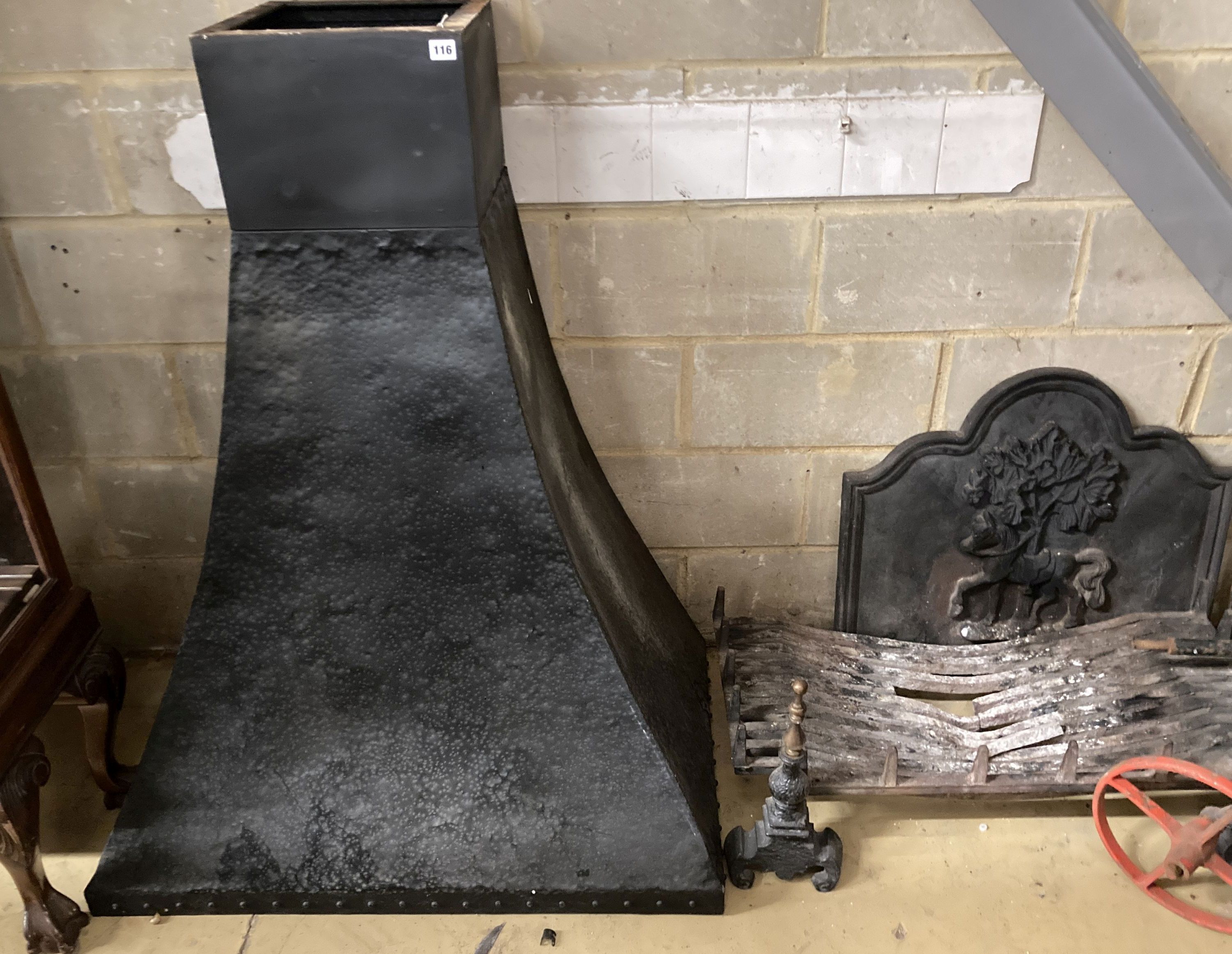 A fireside set comprising of cast iron fire back, basket, width 92cm, height 43cm, pair of dogs and a hammered cowl